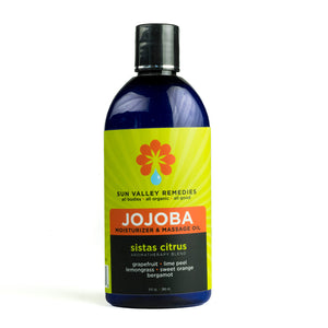 9 ounce cobalt bottle of Sistas Citrus Jojoba oil. The label indicates the aromatherapy is grapefruit lime peel lemongrass sweet orange bergamot