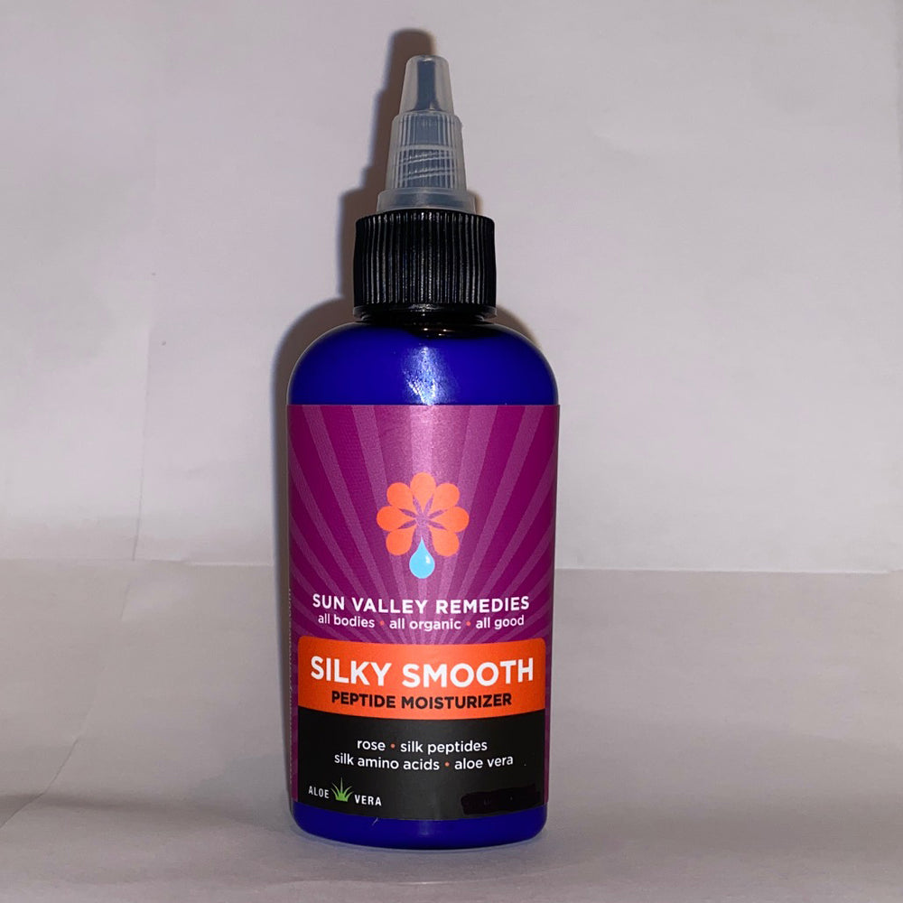 Two ounce cobalt bottle of Silky Smooth, a Peptide Moisturizer. Made with Aloe Vera, rose, silk peptides, silk amino acids