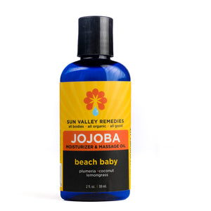 Two ounce Cobalt bottle of Beach Baby Jojoba oil.  The label indicates the aromatherapy is plumeria, coconut, and lemongrass