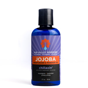Two ounce cobalt bottle of Chillaxin' Jojoba. The label indicates the aromatherapy is mandarin, lavender, and ylang ylang
