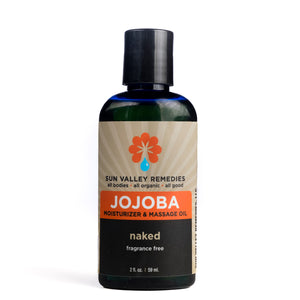 Two ounce cobalt blue bottle of Naked Jojoba oil. The label indicates this is a fragrance free body oil and moisturizer