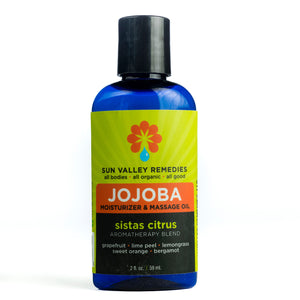 2 ounce cobalt bottle of Sistas Citrus Jojoba oil. The label indicates the aromatherapy is grapefruit lime peel lemongrass sweet orange bergamot