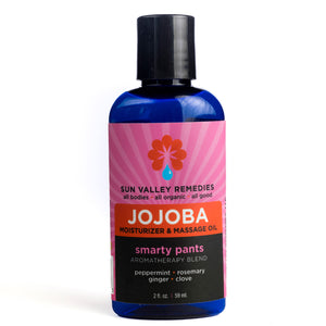 Two ounce cobalt bottle of Smarty Pants Jojoba oil. The label indicates the aromatherapy is peppermint, rosemary, ginger, clove