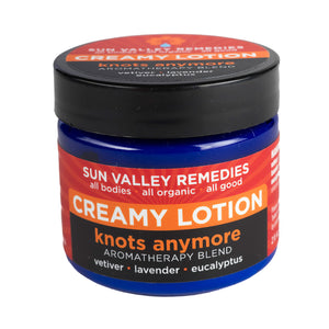 Two ounce cobalt blue jar of Knots Anymore lotion. The label indicates the aromatherapy is vetiver, lavender, and eucalyptus