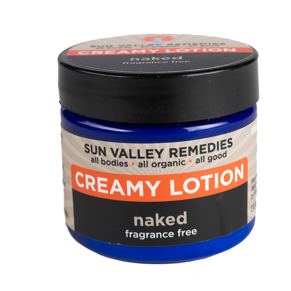 
            
                Load image into Gallery viewer, Two ounce cobalt blue jar of Naked Creamy Lotion. The label indicates this is fragrance free and made with Aloe Vera.
            
        