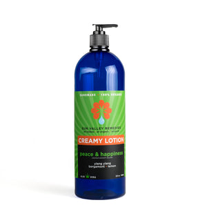 Thirty two ounce cobalt bottle of Peace and Happiness lotion. Label indicates the aromatherapy is ylang ylang, bergamot, lemon