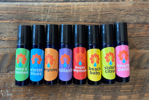Eight cobalt blue rollerballs labeled and filled with eight different aromatherapy blends.