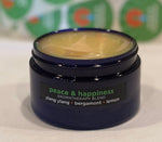 Four ounce cobalt jar of Peace and Happiness Himalayan Salt Scrub.  The label states it has ylang ylang, bergamot, lemon