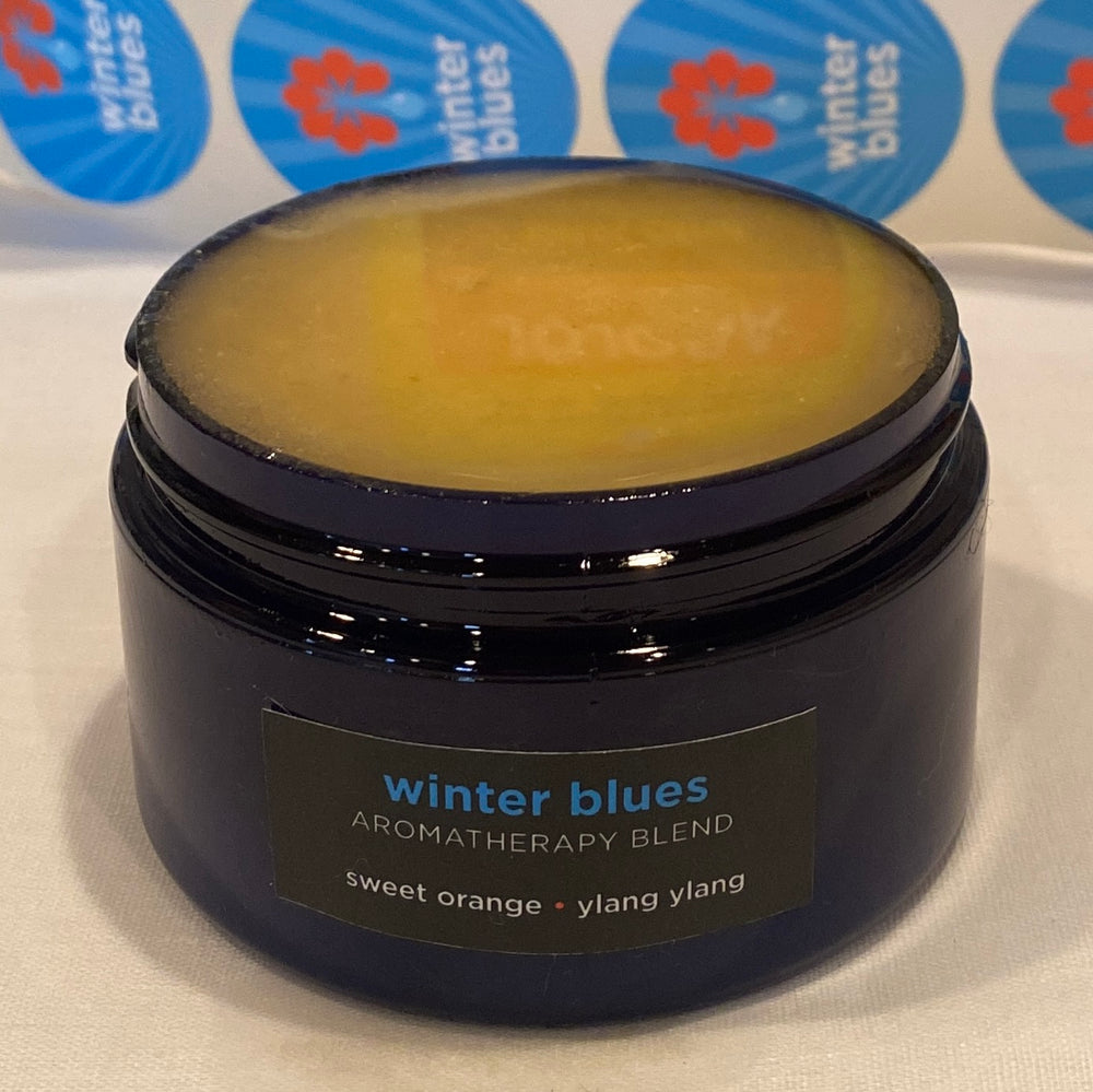 Four ounce cobalt jar of Winter Blues Himalayan Salt Scrub.  The label states the aromatherapy is sweet orange and ylang ylang