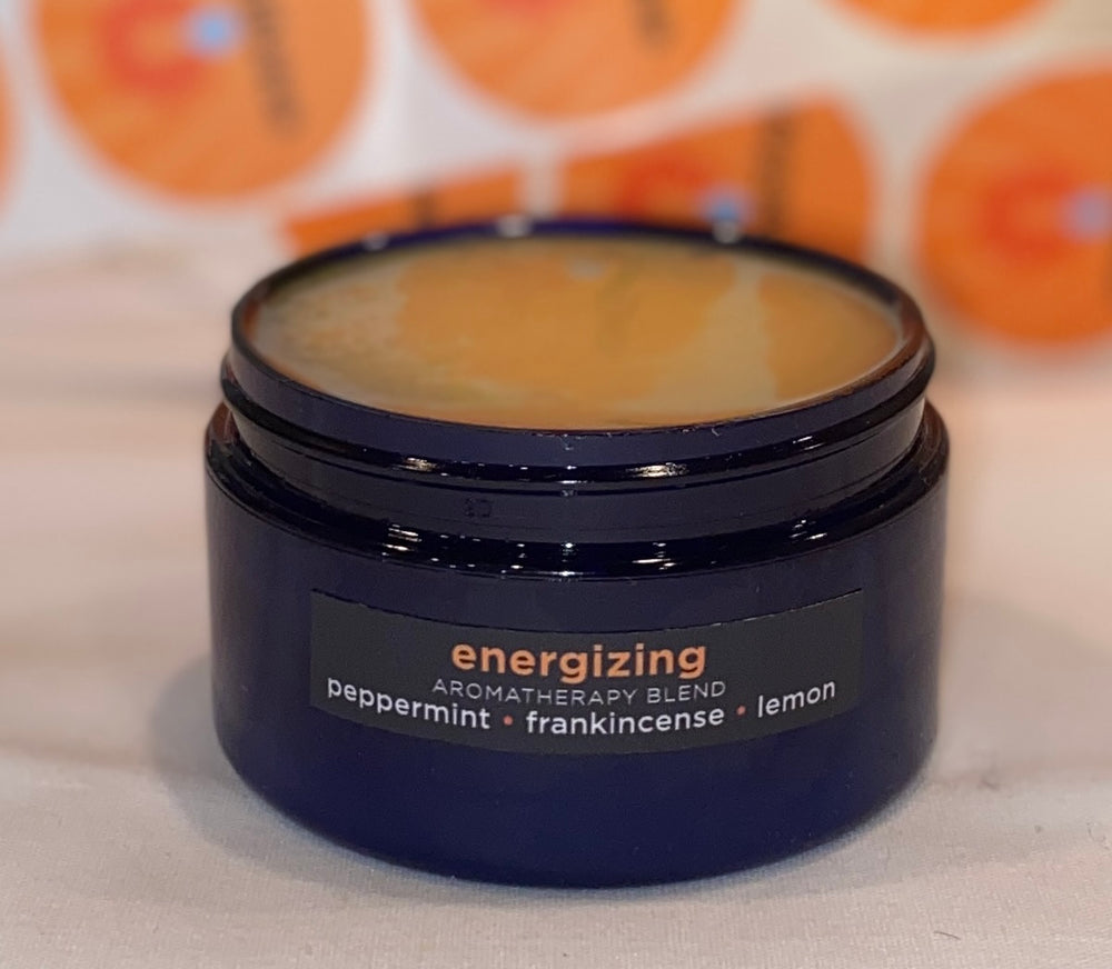 Four ounce cobalt jar of Energizing Himalayan Salt Scrub. The label indicates aromatherapy of peppermint, frankincense, lemon