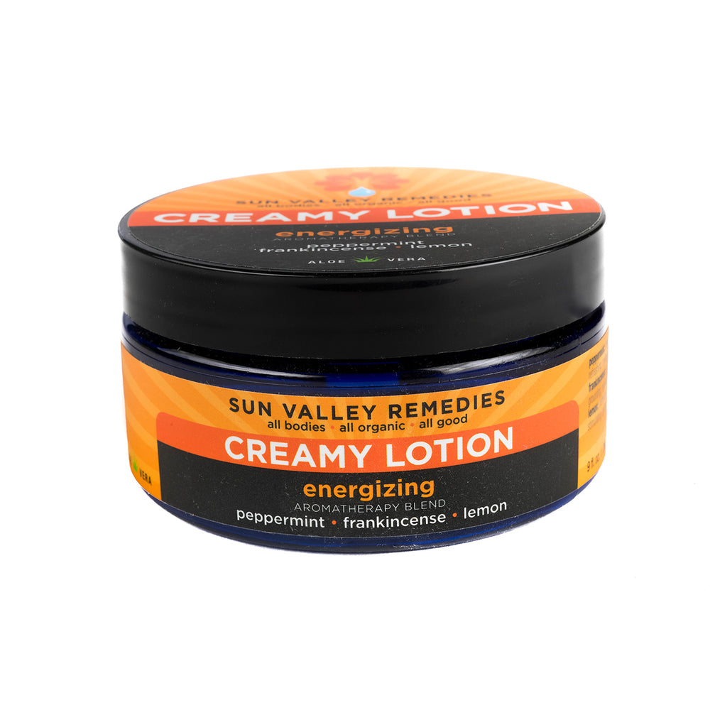 Nine ounce cobalt bottle of Energizing lotion. The label indicates the aromatherapy is peppermint, frankincense, and lemon