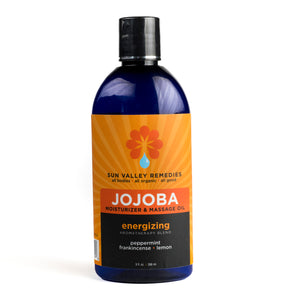 Nine ounce cobalt bottle of Energizing Jojoba oil. The label indicates the aromatherapy is peppermint, frankincense, lemon