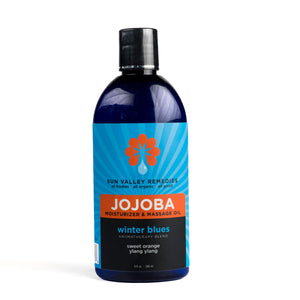 Nine ounce cobalt bottle of Winter Blues Jojoba oil. The blue label indicates the aromatherapy is sweet orange and ylang ylang