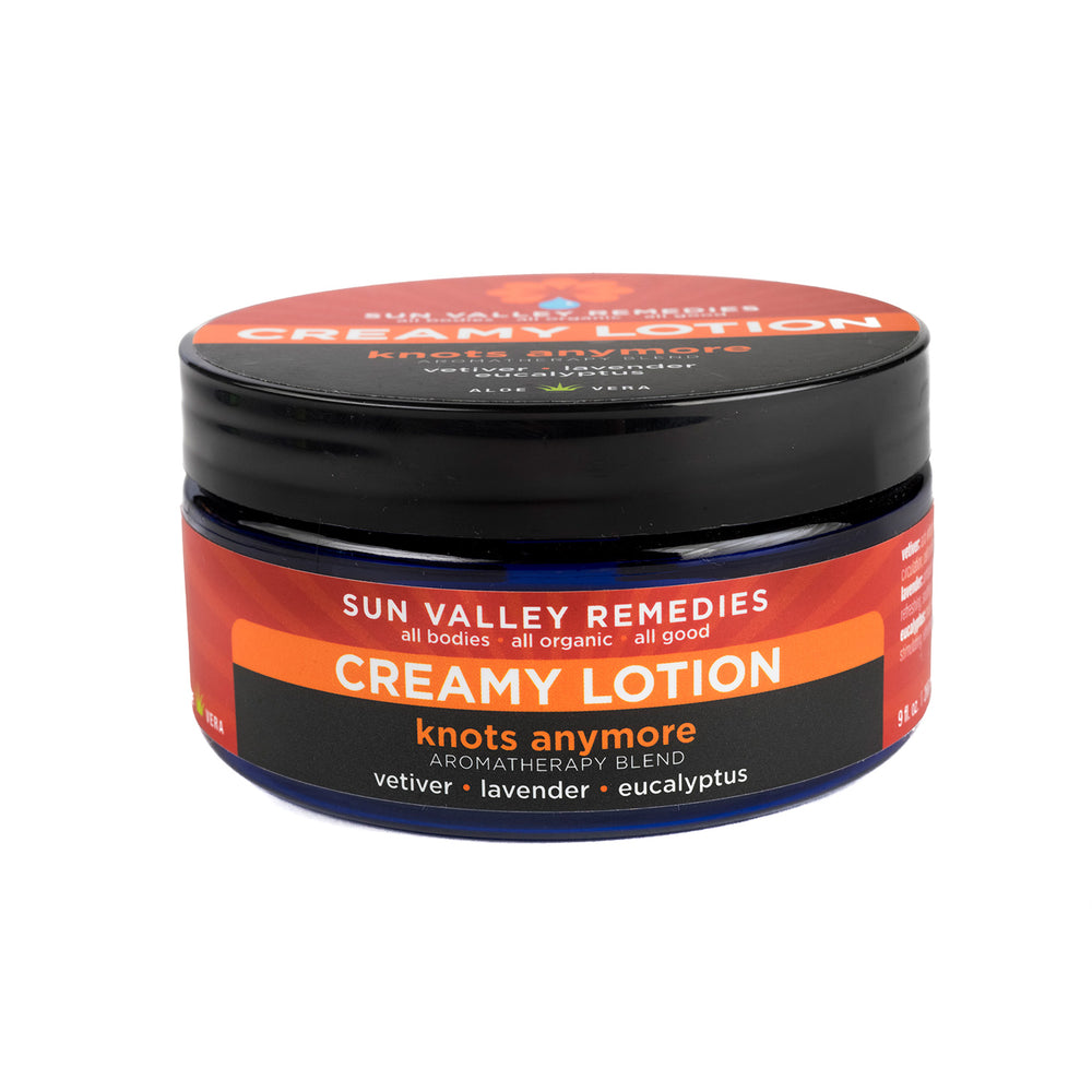 Nine ounce cobalt blue jar of Knots Anymore lotion. The label indicates the aromatherapy is vetiver, lavender, and eucalyptus