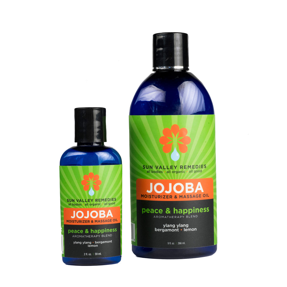 
            
                Load image into Gallery viewer, Two cobalt bottles of Peace and Happiness Jojoba Oil. The green label reads the aromatherapy is ylang ylang, bergamot and lemon
            
        