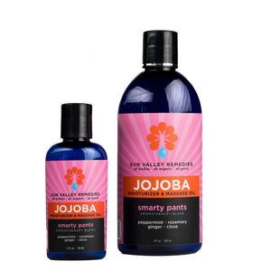 Two cobalt bottles of Smarty Pants Jojoba oil. The pink label indicates the aromatherapy is peppermint, rosemary, ginger, clove